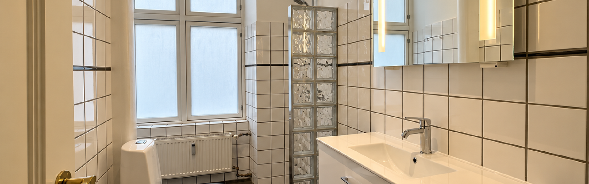 Skandinavisk badeværelse med glasblokke og spejl lys